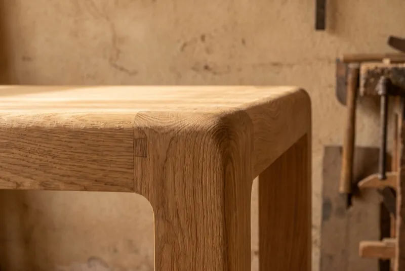 Detalhe de topo de mesa em carvalho maciço: o veio a contornar a aresta, junto a uma junta de marcenaria